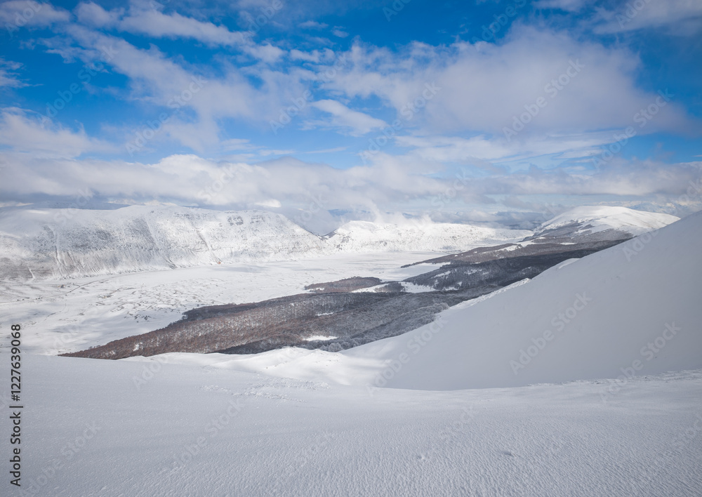 Campo Felice, Italy - The suggestive plateau peak in Abruzzo region, Monte Puzzillo and Morretano summit mount range, during the winter with snow and alpinists in altitude