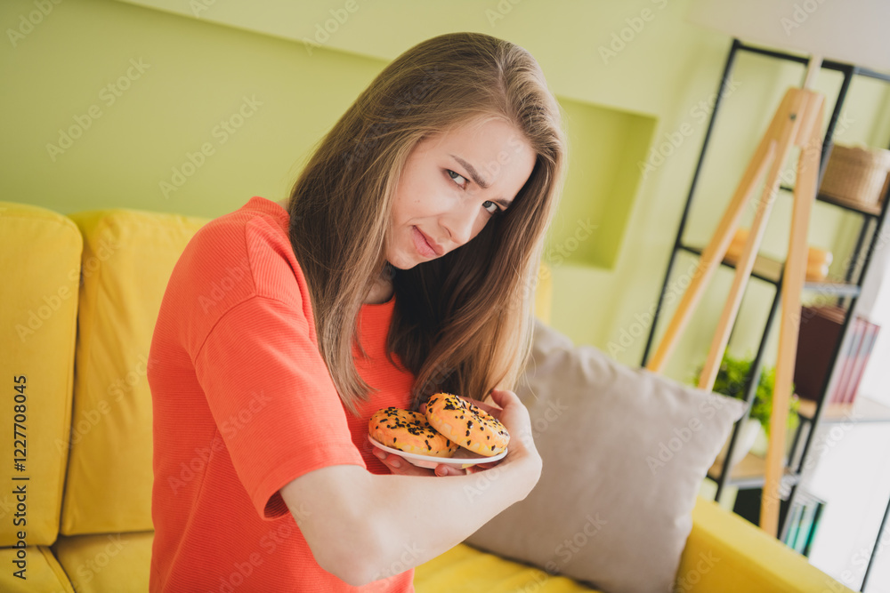 Photo of attractive young woman greedy protect donut dressed orange outfit cozy day light spring home interior living room Photo of attractive young woman greedy protect donut dressed orange outfit cozy day light spring home interior living room