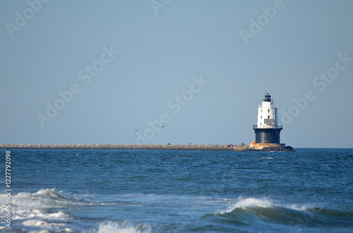 Harbor of Refuge Lighthouse in Cape Henlopen State Park with waves in foreground