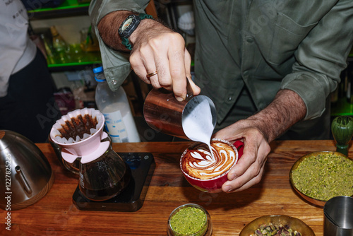 Barista crafting a specialty coffee with latte art skills photo