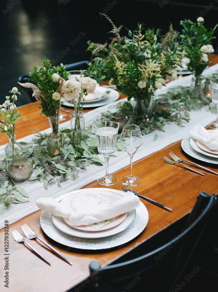 Fototapeta premium Elegant dinner table setup featuring floral decorations and fine tableware in a modern venue during an evening gathering