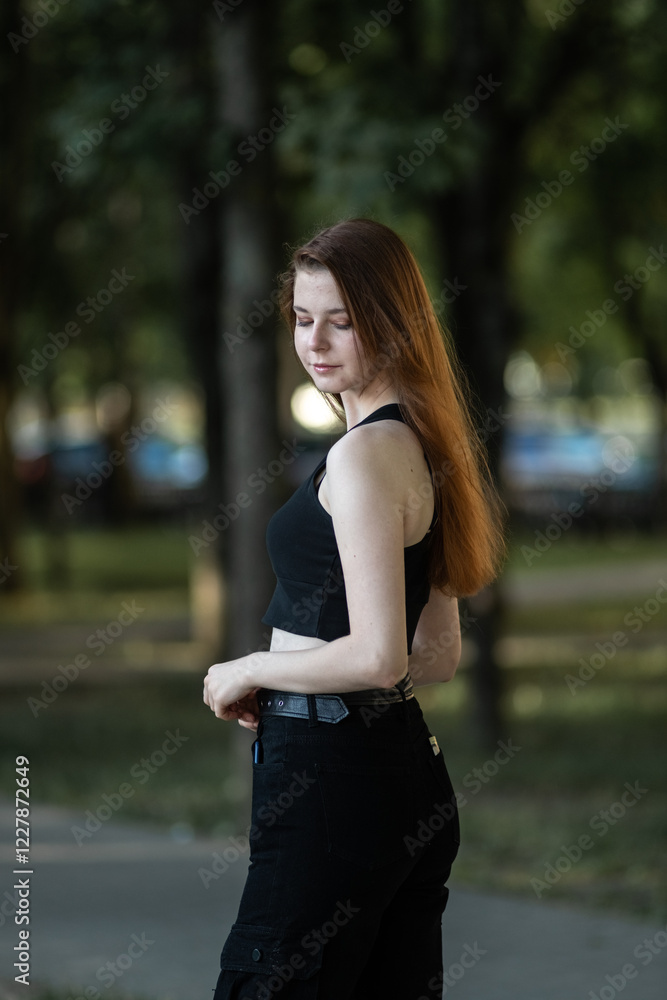 Young beautiful girl in summer in dark clothes in urban environment. Young beautiful girl in summer in dark clothes in urban environment.