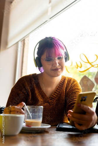 Obraz na plátně Body positive autistic woman using smartphone and drinking latte in cafe