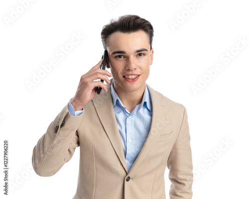 young businessman in beige suit talking on the phone photo