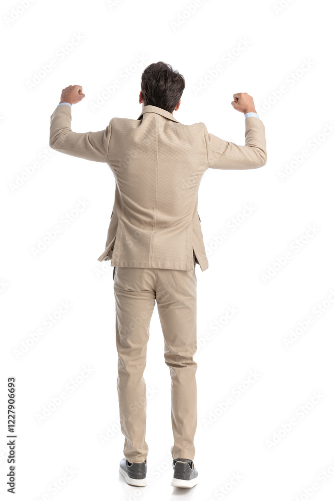 rear view of young smart casual man celebrating rear view of young smart casual man celebrating