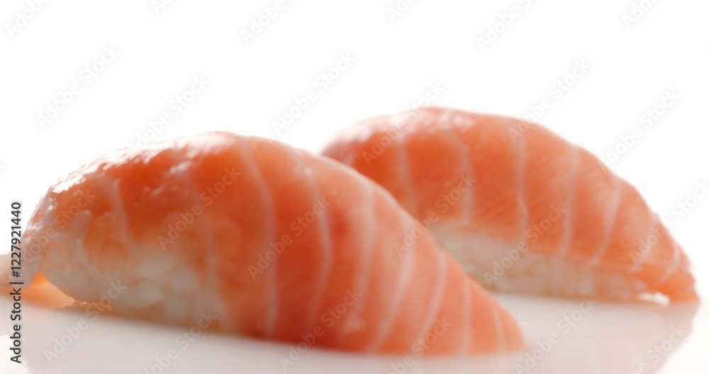 fresh salmon nigiri sushi ready to eat and picked up using chopsticks while isolated in white background fresh salmon nigiri sushi ready to eat and picked up using chopsticks while isolated in white background