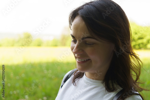 Wallpaper Mural Cute smiling girl in a white T-shirt and with a backpack on her shoulders against the background of a green summer field. Active hiking travel concept Torontodigital.ca