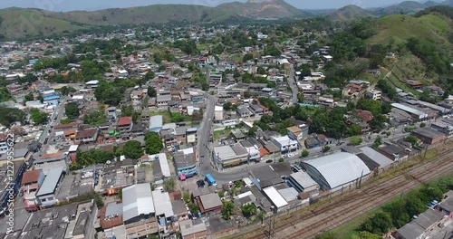 Imagens aéreas de Japeri capturam a região ao redor da histórica estação de trem, revelando a interação entre o patrimônio ferroviário e a paisagem local. O drone sobrevoa suavemente a área, destacand photo