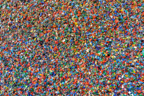 A large collection of small colorful plastic fragments. These fragments are of various shapes and sizes and are scattered densely throughout the frame.