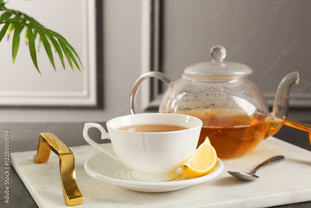 Refreshing green tea, spoon and slice of lemon on dark textured table Refreshing green tea, spoon and slice of lemon on dark textured table