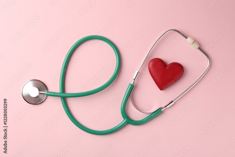 Cardiology. Stethoscope and red decorative heart on pale pink background, flat lay Cardiology. Stethoscope and red decorative heart on pale pink background, flat lay