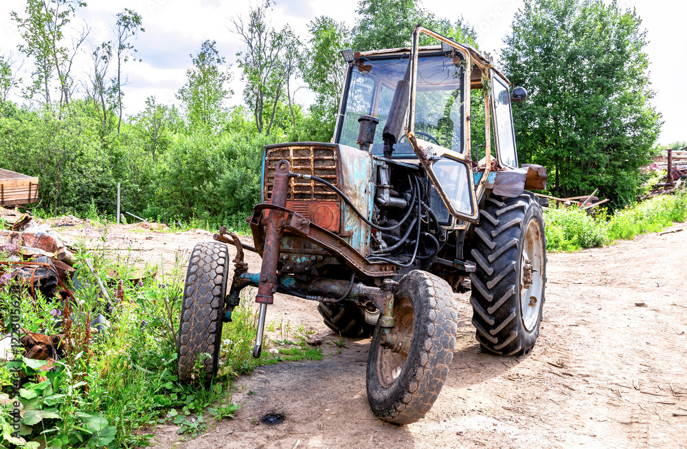 Old rusty wheeled tractor at the village in summer Old rusty wheeled tractor at the village in summer