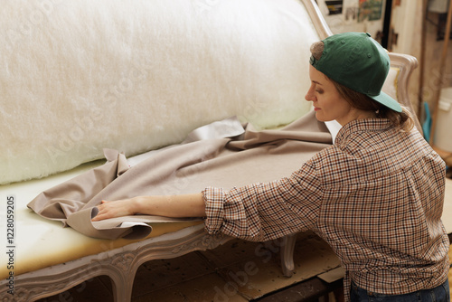 Photos Young woman in workshop restoring old furniture by upholstering armchair replacing fabric to give fresh look focusing on craftsmanship and detail in refurbishment process