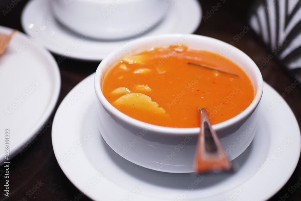 Warm tomato soup served in a bowl with spoon Warm tomato soup served in a bowl with spoon