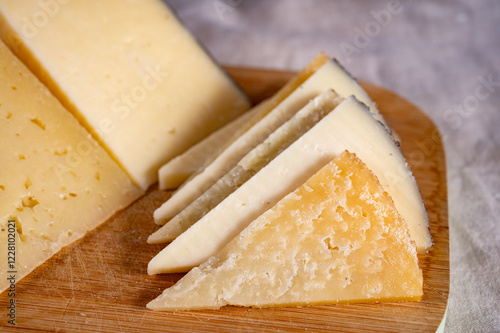 Assortment of Spanish hard cheeses, curado, manchego, goat cheese served for tasting, close up photo