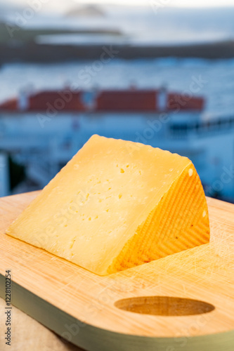 Spanish hard cheese, curado, manchego, goat cheese served outdoor with blue sea on background, close up photo