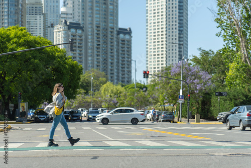 Wallpaper Mural Young woman crossing street in urban setting while talking on phone Torontodigital.ca