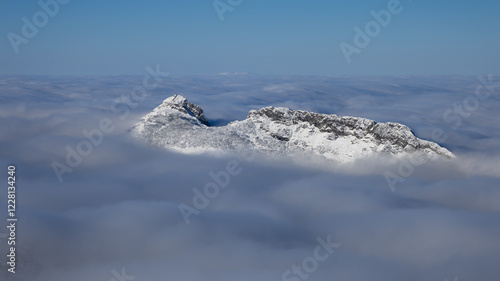Fototapeta Naklejka Na Ścianę i Meble -  Panorama of the winter peaks of the Tatras from Kasprowy Wierch. A sunny, winter December day. The mountain peaks are covered in thick clouds.