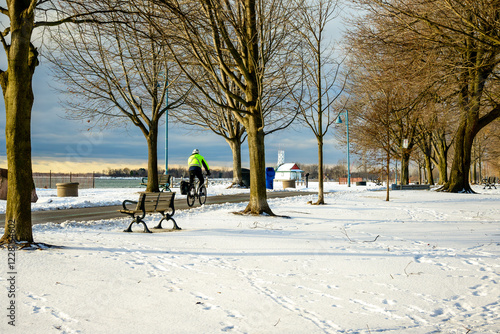 winter bike commuter on the martin goodman trail first thing in the morning on cleared pavement following an overnight snowfall room for text shot toronto beaches in January  photo