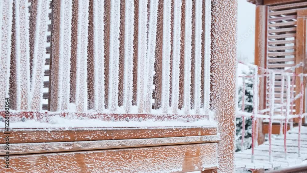 Snow-covered climbing slides on a playground against the background of a snow-covered park in winter.