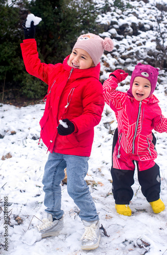 Brother and sister play snowballs