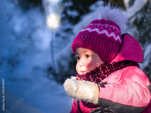A child in the glare of sunlight in a winter forest