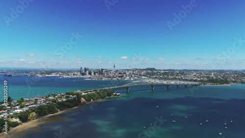 Auckland’s Waitemata Harbour, featuring Harbour Bridge, marina, and downtown skyline in vibrant daylight, aerial establish photo