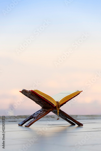 A serene moment of faith. A Quran and prayer beads rest against a backdrop of a tranquil nature scene, with a minaret subtly placed in the distance.