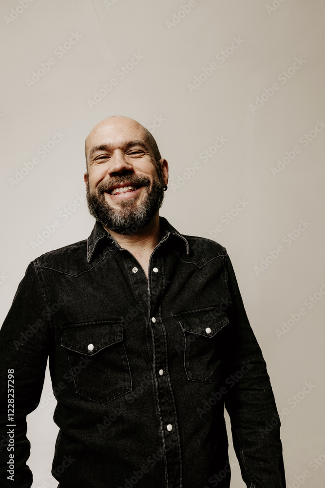 Obraz premium Vertical headshot of smiling bearded mature man looking away posing indoor. Mindset concept.