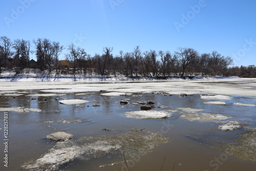 wide-angle river ice and snow slowly melting in warm sunshine at spring breakup