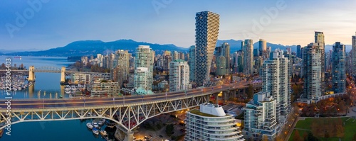 Vancouver skyline at dawn, featuring the iconic Granville Bridge, modern high-rises, and a vibrant harbor. City life at sunrise.  Vancouver, British Columbia, Canada