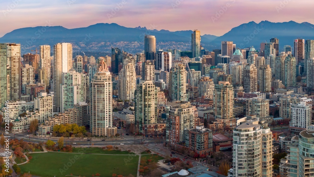 Naklejka premium Vancouver skyline at dawn, showcasing high-rise buildings and the city's urban landscape. Modern architecture against a backdrop of mountains. British Columbia, Canada