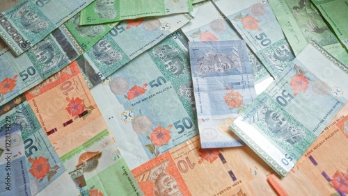 Colorful malaysian ringgit banknotes scattered on a flat surface, highlighting the vibrant currency of malaysia with various denominations visible.