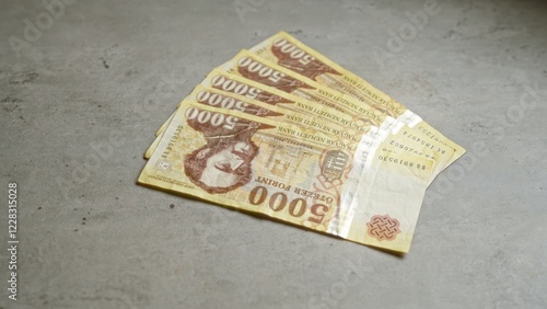 Hungarian forint banknotes on a grey concrete surface illustrate currency and finance in hungary, highlighting money and economic themes. photo