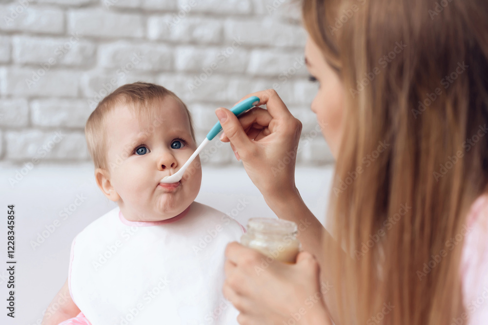 Young mother with spoon feeding little baby. Newborn, motherhood concept. Young mother with spoon feeding little baby. Newborn, motherhood concept.