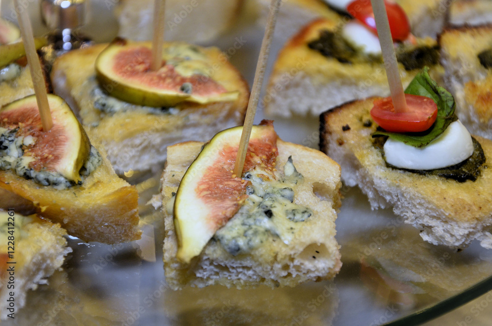 Tasty canapés with gorgonzola cheese and a slice of fig on the plate on the table Tasty canapés with gorgonzola cheese and a slice of fig on the plate on the table