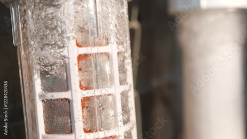 Water filtration system with visible dirt on stainless and paper filter cartridges in operation. photo