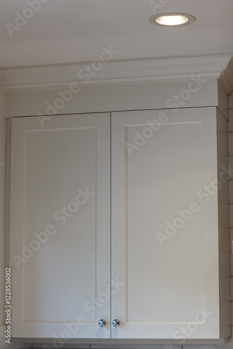 White cabinets with handles in the kitchen, white kitchen cabinet with silver handles against a background of white boot and walls