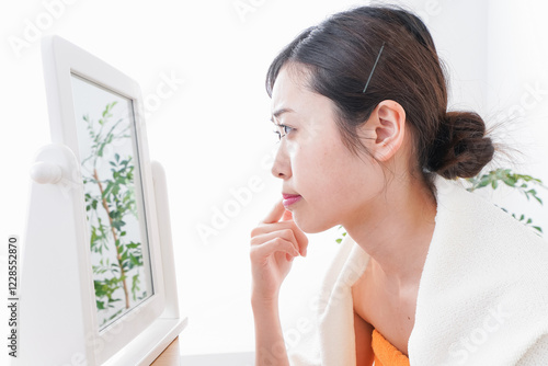 部屋でスキンケアをする若い女性 photo