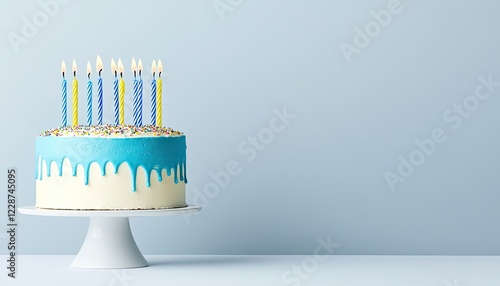 A beautifully decorated birthday cake with blue icing and colorful candles on a light background