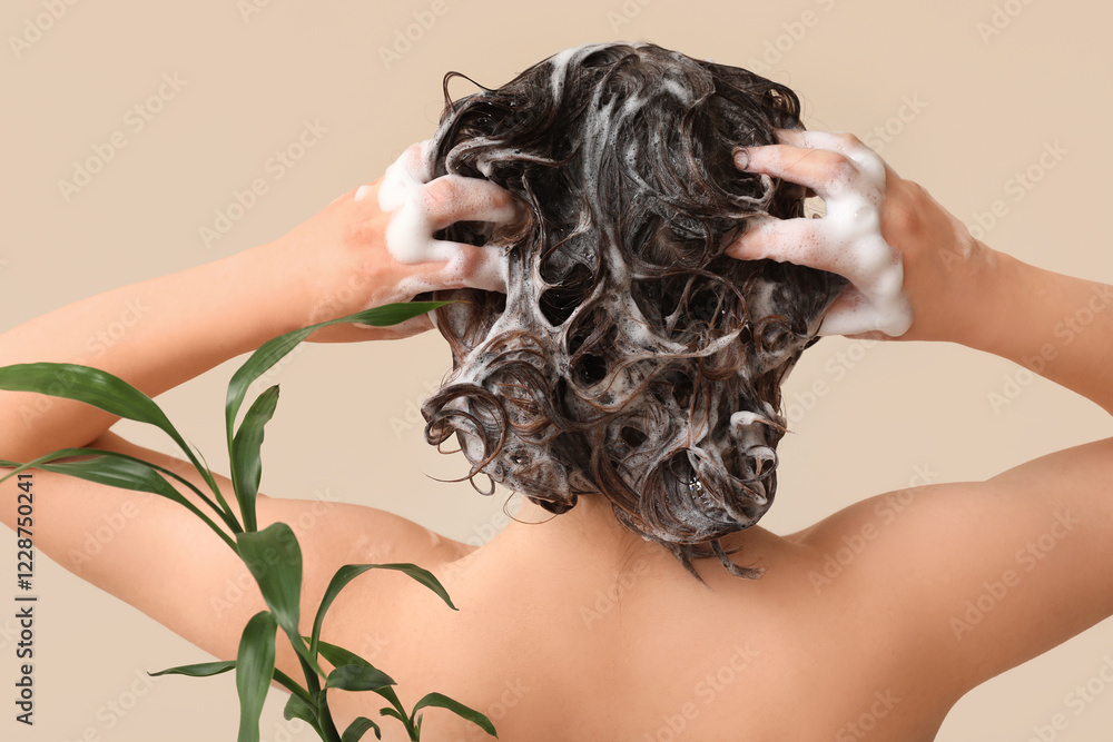 Beautiful young woman with bamboo branches washing hair on beige background, back view Beautiful young woman with bamboo branches washing hair on beige background, back view