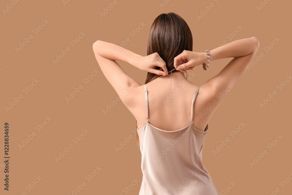 Pretty young woman in stylish dress with accessories on beige background, back view Pretty young woman in stylish dress with accessories on beige background, back view