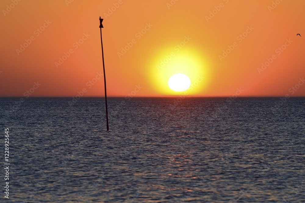 Setting sun with yellow corona beside a sea sign, Amrum, North Frisian island, North Frisia, Schleswig-Holstein, Germany, Europe Setting sun with yellow corona beside a sea sign, Amrum, North Frisian island, North Frisia, Schleswig-Holstein, Germany, Europe
