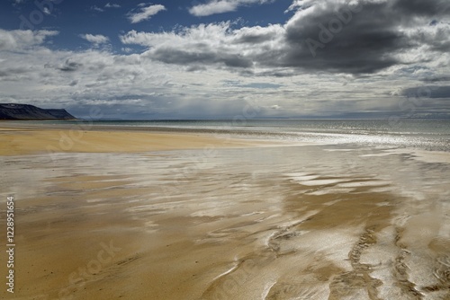 Brighter sandy beach with back light, dramatic clouds, Brekkuvellir, Westfjorde, Nordurland vestra, Iceland, Europe photo