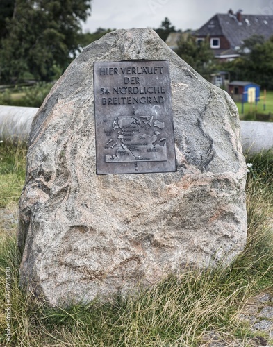 Sign on a glacial boulder stone with information, 54. degree northern latitude, Friedrichskoog, Schleswig-Holstein, Germany, Europe photo