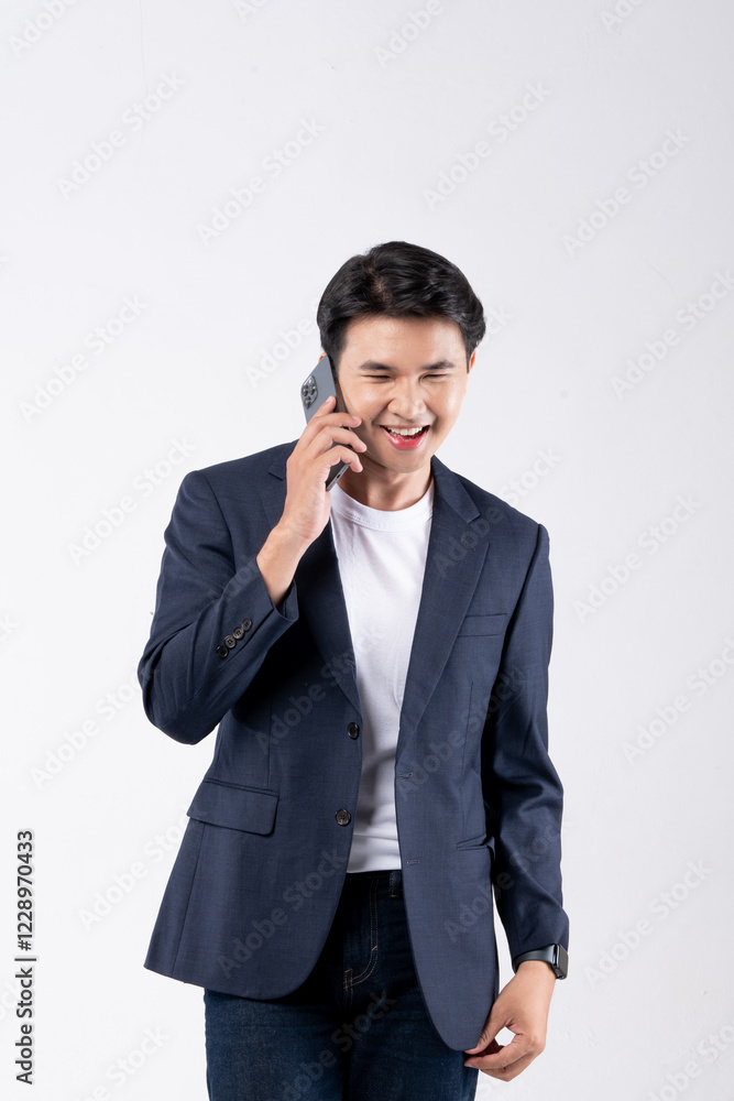 A man in a suit is smiling while looking at his cell phone A man in a suit is smiling while looking at his cell phone