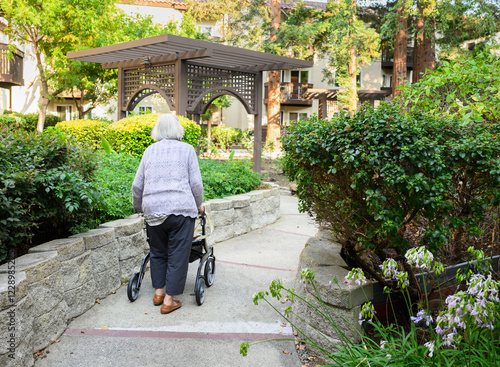 Obraz na płótnie Elderly woman walking using a mobility walker in the retirement village. California. w salonie