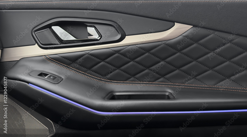 Door handle with power window control buttons. Black perforated leather interior with stitching. Modern car black leather interior details. Door handle with power window control buttons. Black perforated leather interior with stitching. Modern car black leather interior details.