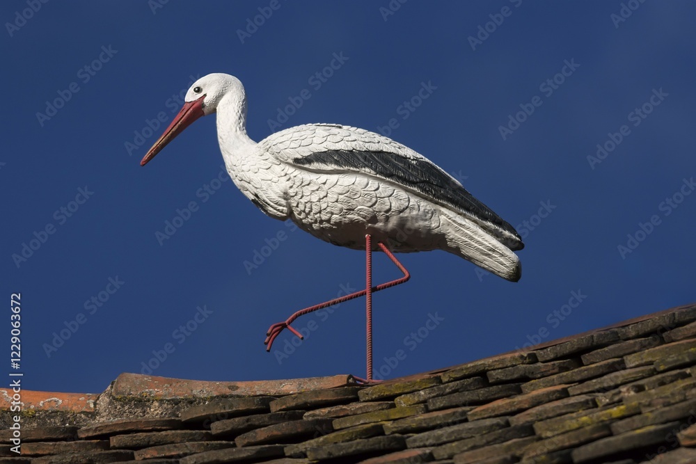 Fototapeta premium White stork figure on a roof, blue sky, Ribeauvillé, Alsace, France, Europe
