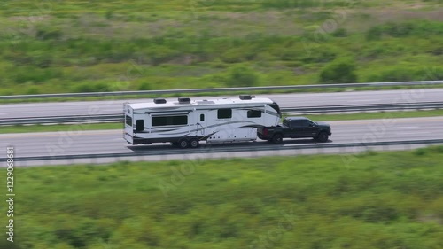 Truck towing RV camper trailer driving at high speed on American freeway in Florida. USA travel transportation infrastructure